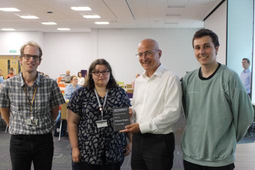 Three members of the Turning Pages team receiving the green impact award from Vice-Chancellor Charlie Jeffrey